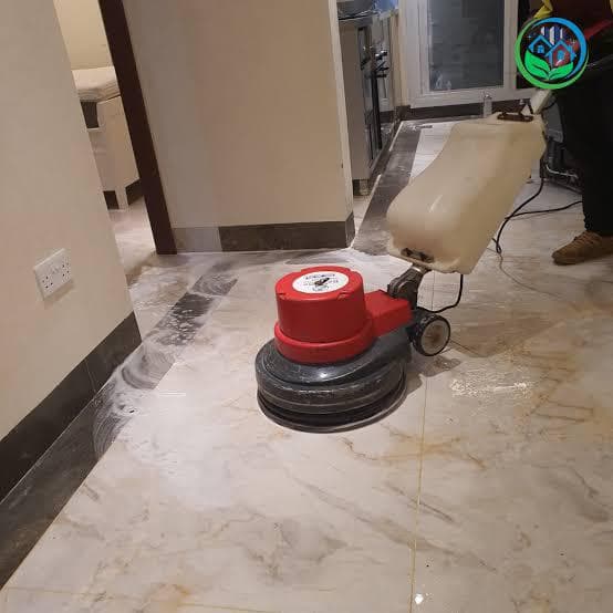 Professional floor buffer polishing marble tiles to a high shine in a modern home after builders cleaning